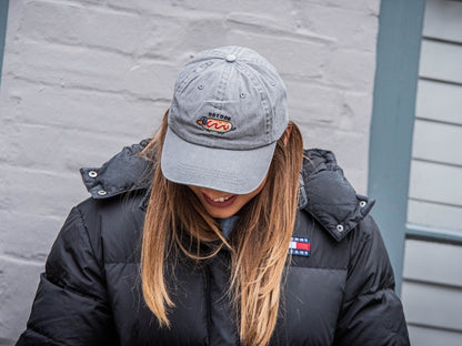 Grey denim baseball cap with embroidered dachshund hot dog design.